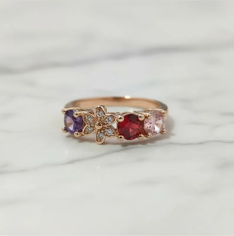 Anillo de diseño floral con circonias en tonos rojo, lila y rosa sobre base dorada rosada – joya delicada y significativa de Veramorest.