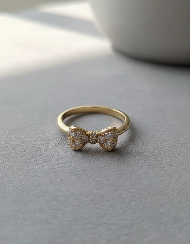 Anillo dorado con moño central decorado en circonias – diseño elegante y femenino con inspiración espiritual | Veramorest.