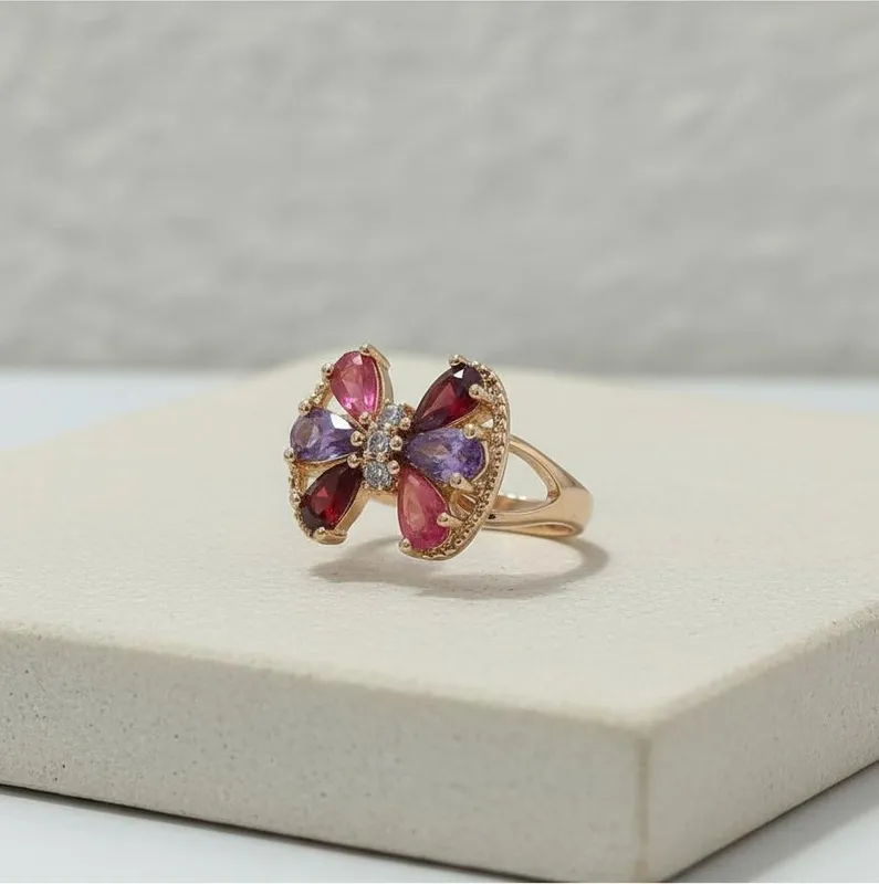 Anillo dorado con forma de lazo y cristales en tonos rosado, violeta y rojo – diseño alegre y sofisticado Veramorest.